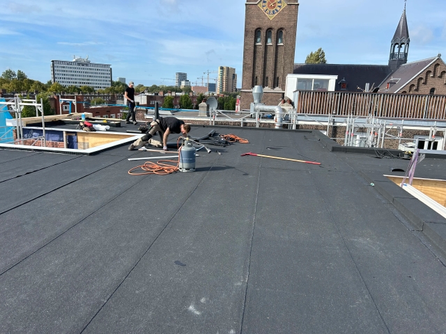 Dakdekkers van De Dakmannen voeren onderhoudswerkzaamheden uit aan een woning in de regio Zaandam.